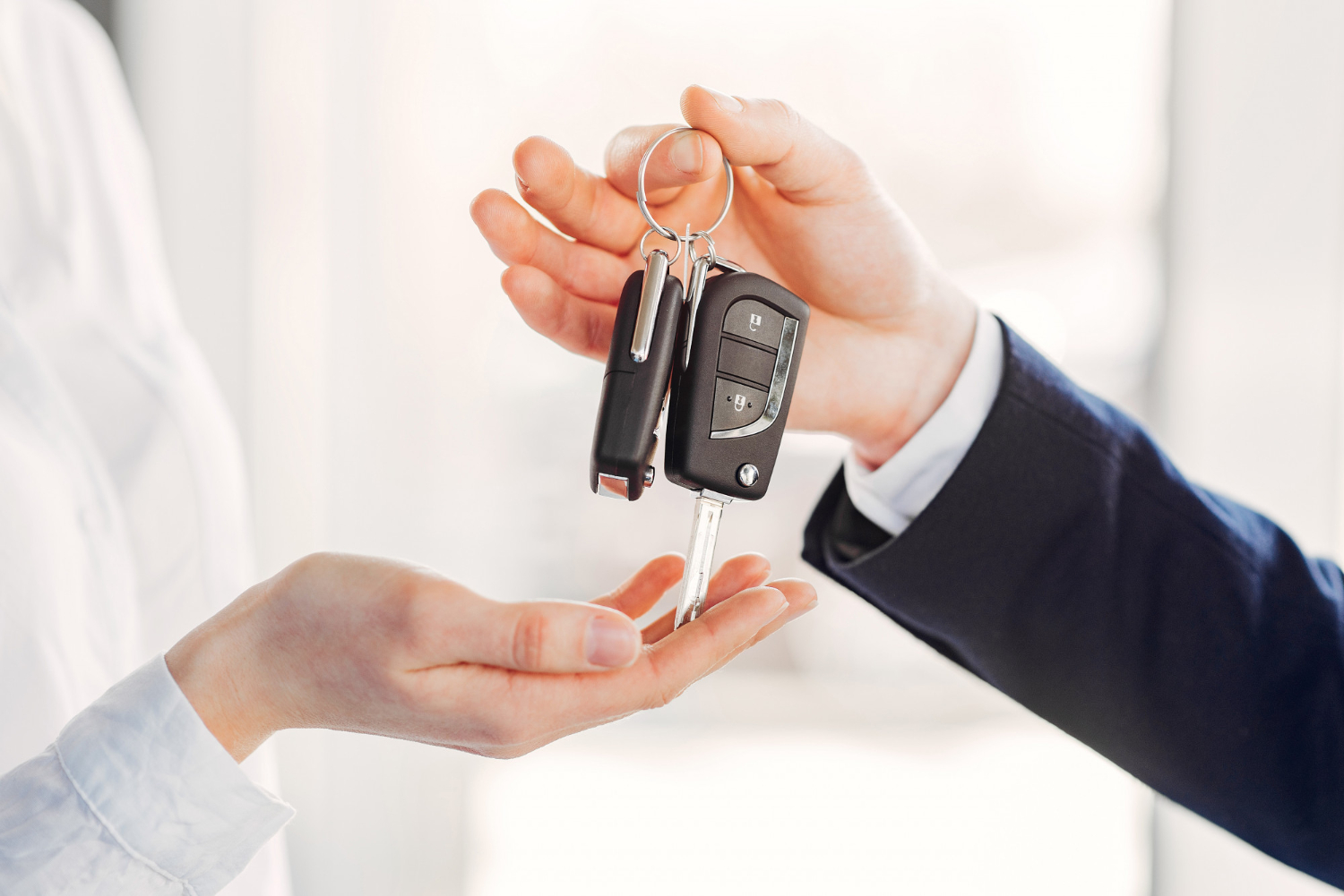 Dealer handing over keys after a used car sale