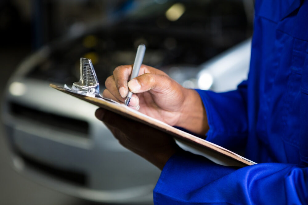 Person inspecting a used car and referencing their checklist
